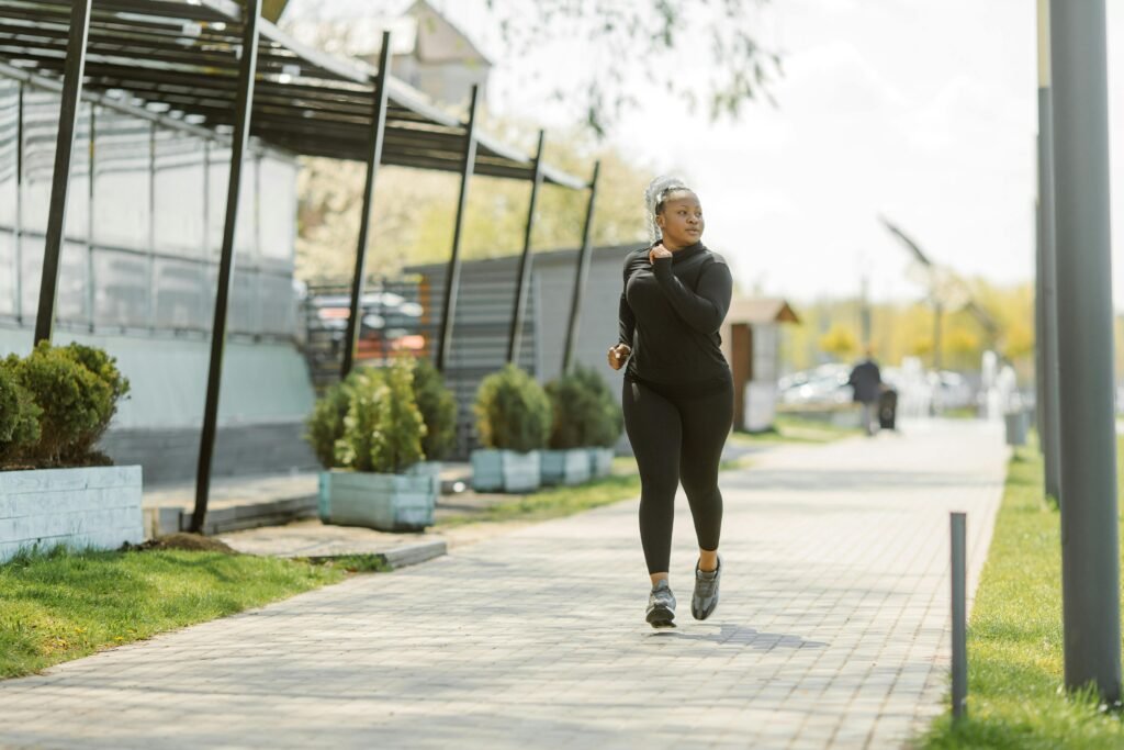An African American woman jogging on a sunny day, embracing a healthy lifestyle.